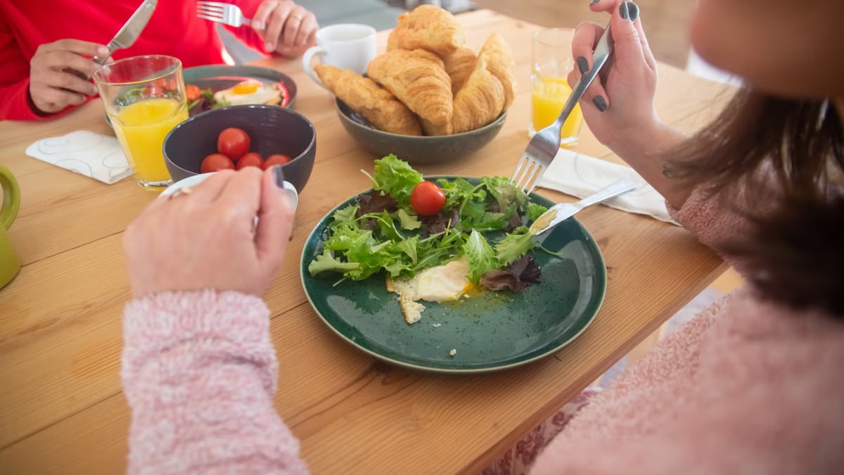Cozy breakfast scene with fresh salad, croissants, and juice, perfect for a healthy morning.